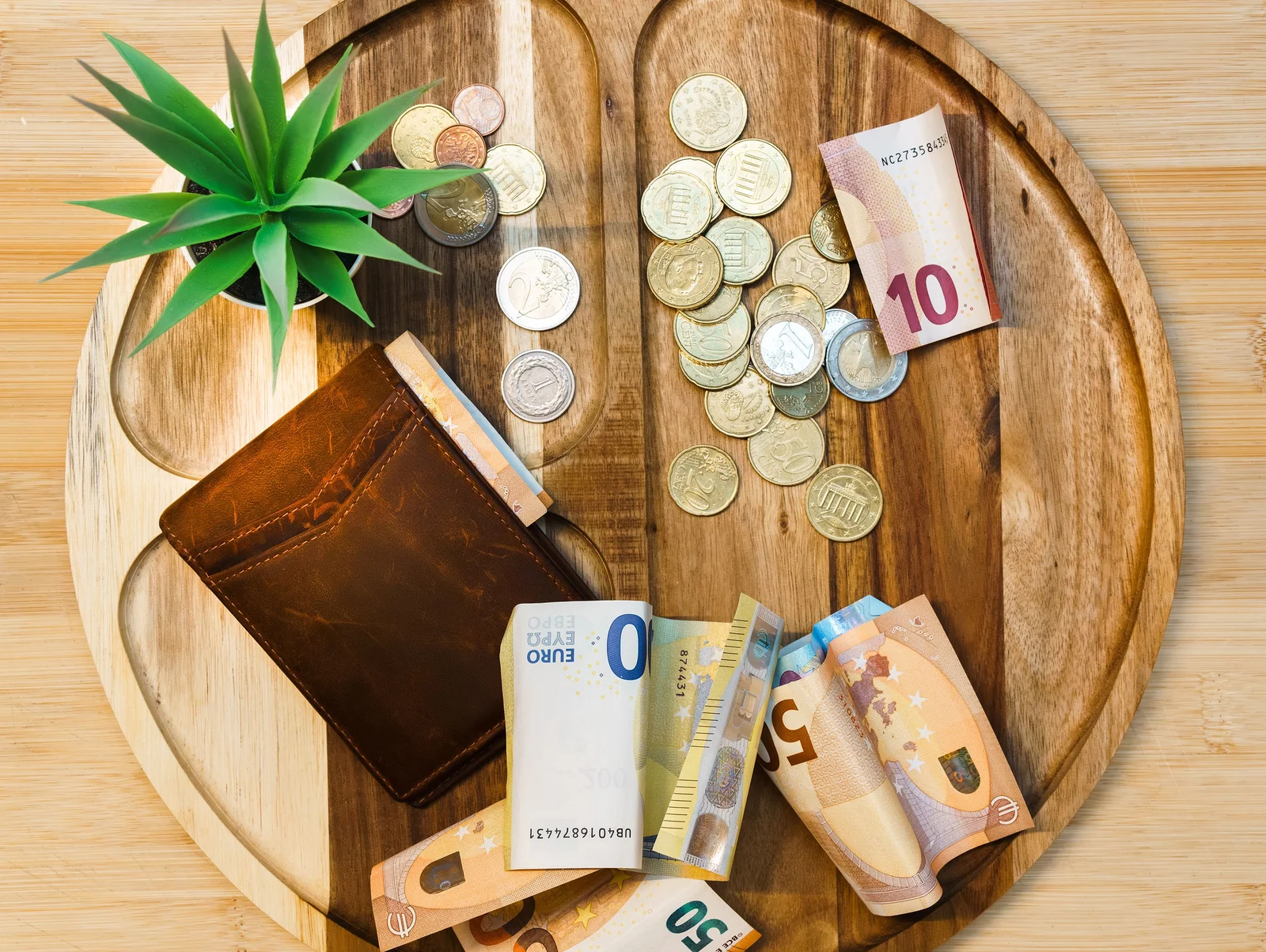 Billets et pièces en euros posés sur une table en bois